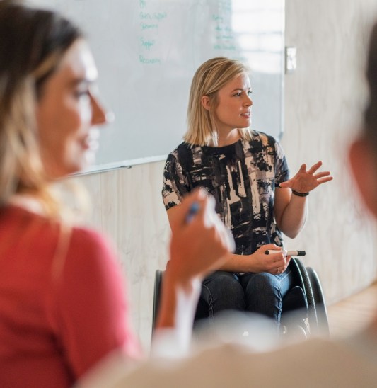 Disabled manager explaining strategy in office